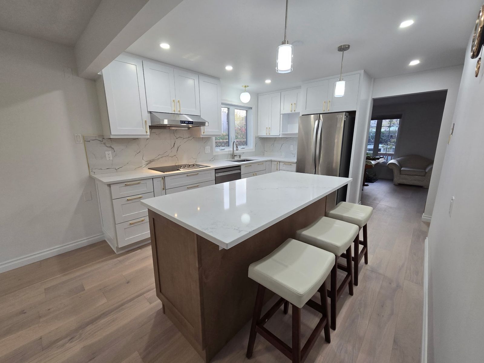 Finished kitchen with Canada Kitchen Shaker White cabinets and a wood island