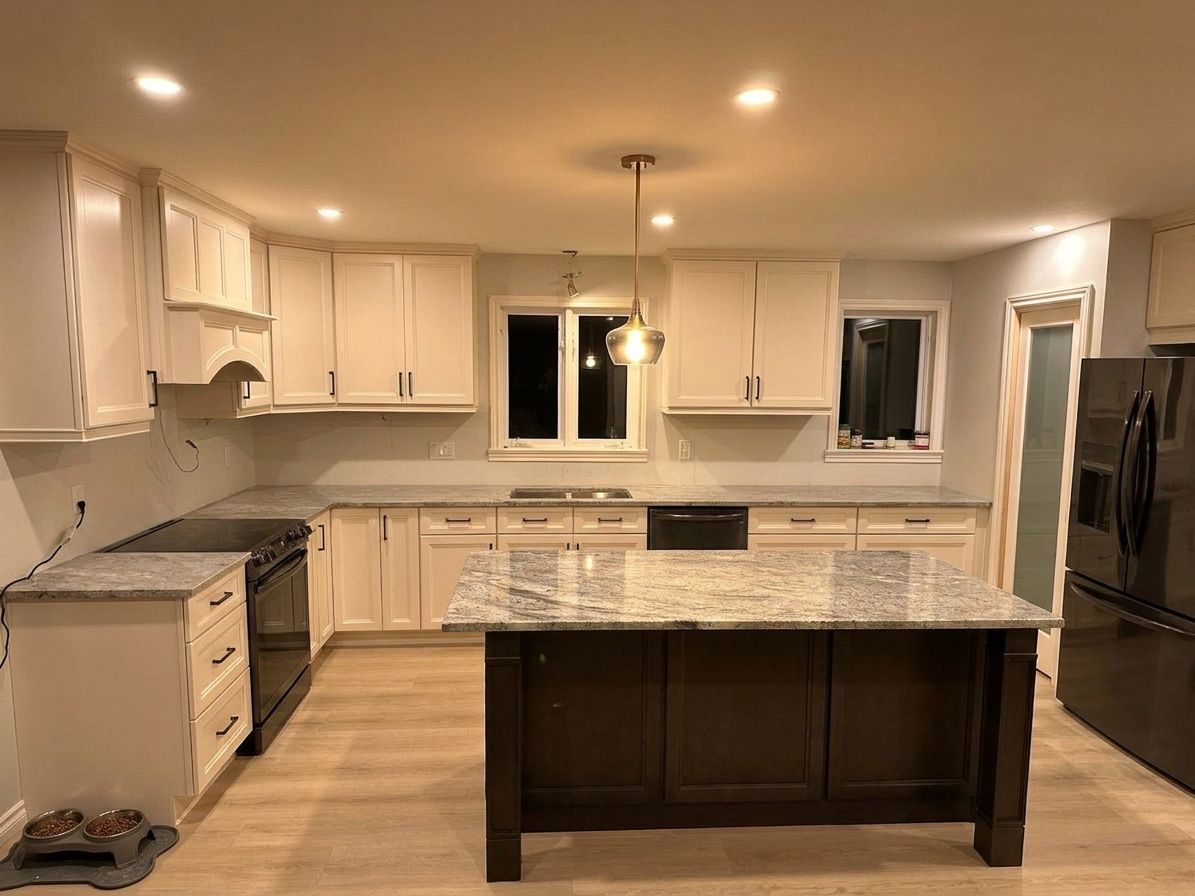 Finished kitchen with white cabinets, a dark island and a pendant light